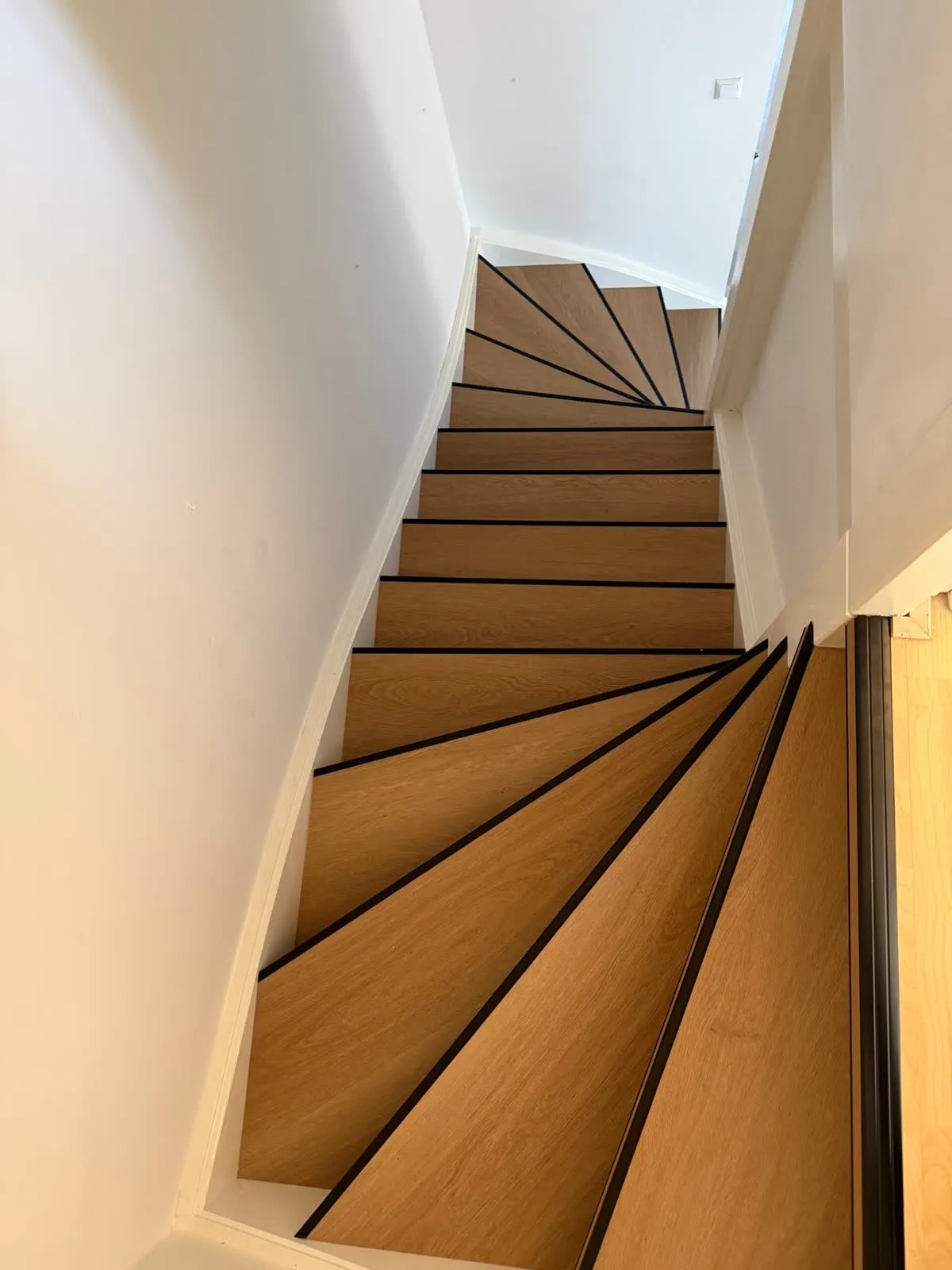 Draaiende trap gerenoveerd met licht eiken houtdecor